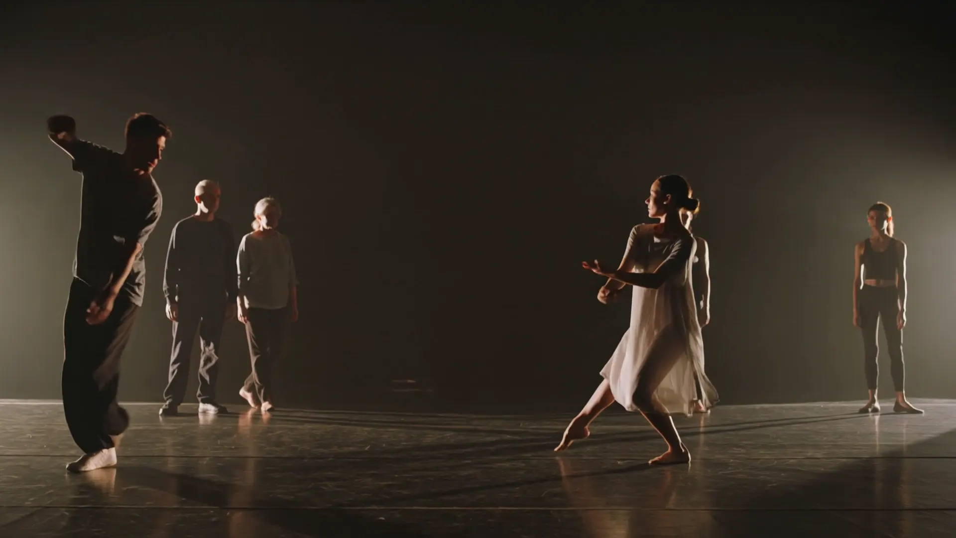 Dancers of different styles in a dark studio, each moving to their own rhythm